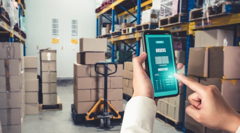 Person holding a mobile phone viewing an order in a warehouse