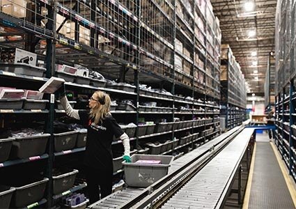Lady picking orders in a logistics warehouse prior to despatch