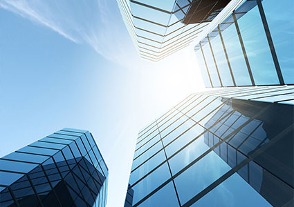 View of high rise glass office building on blue sky