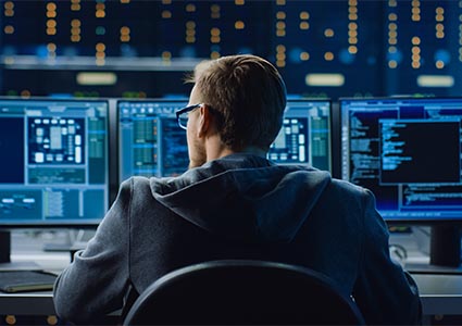 IT Specialist Working on Personal Computer with Monitors Showing Coding Language Program. Technical Room of Data Center with Server Rack