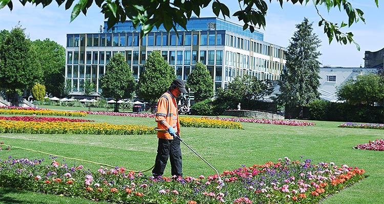 How Ubico keeps communities clean and green with smart and sustainable solutions a gardener watering a flowerbed in a park or garden