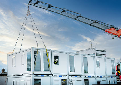 a modular building unit being lifted by a crane