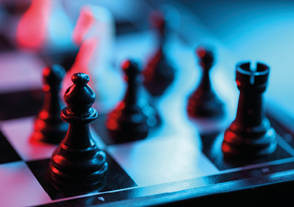 a close-up, dramatic shot of black chess pieces on a chessboard