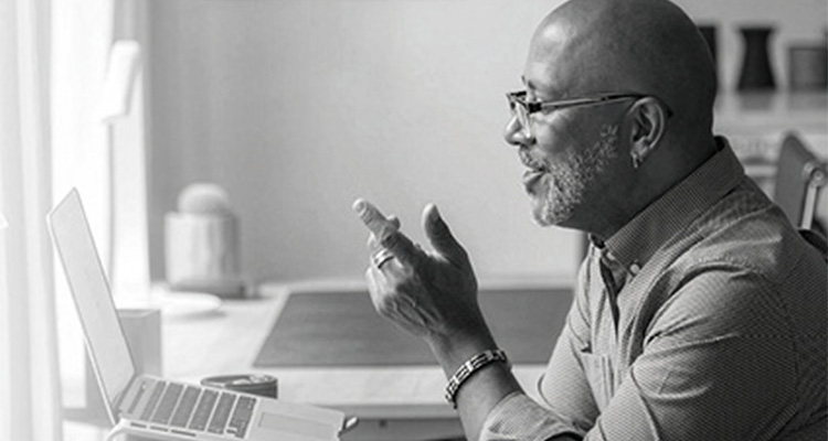 a man wearing a button-down shirt and glasses while working at a desk.
