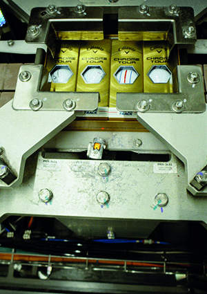 a close-up shot captures a stage in the automated manufacturing or packaging process of premium golf balls