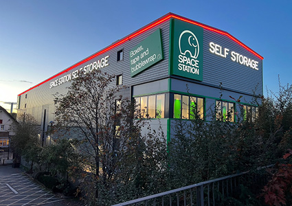 the exterior of a large, modern commercial self-storage facility at dusk.