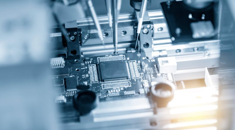 Robotic inspection equipment testing semiconductor components on a printed circuit board production line as Apple expand microchip strategy.