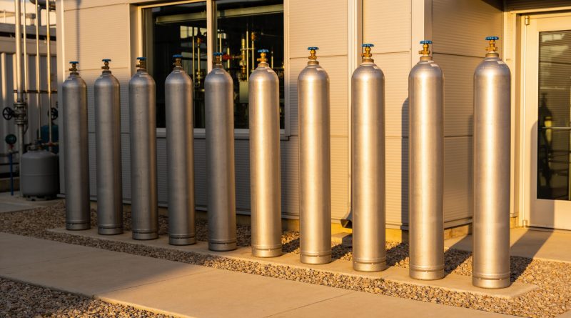 Industrial gas storage tanks at a helium processing facility representing global supply chain disruption affecting semiconductor and advanced manufacturing industries.