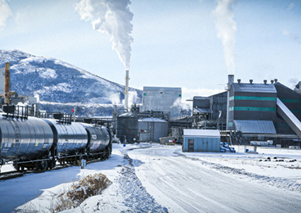 an industrial manufacturing facility, such as a paper mill or processing plant, during winter
