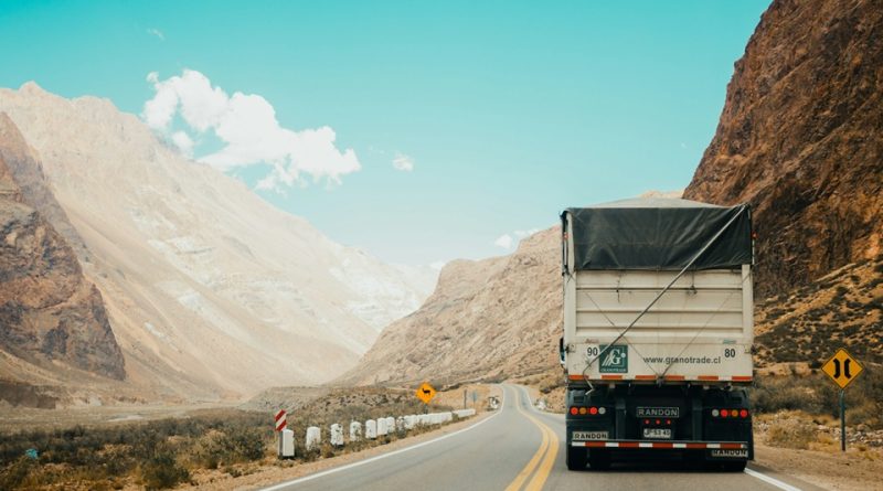 Freight truck travelling through a mountainous region, representing high-performance fastener supply chain logistics.