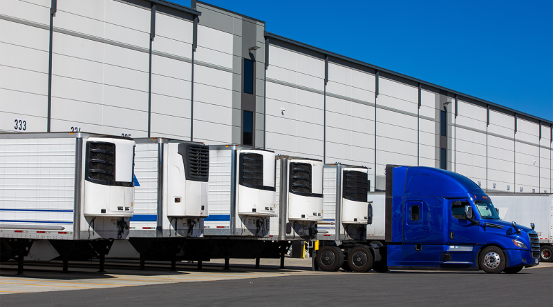 parked refrigerated semi truck trailers in cold storage warehouse
