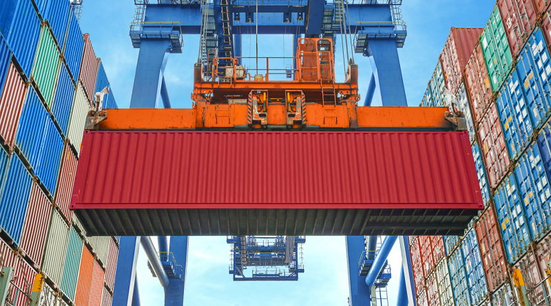 Shore crane loading containers in freight ship
